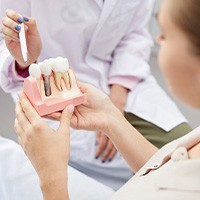 Patient in St. Albans looking at dental implant model