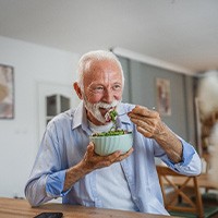 Man smiling while eating lunch at home