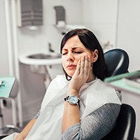 A woman experiencing a toothache at a dentist’s office