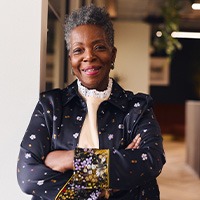 Woman in black blazer smiling in office
