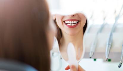 Woman looking at smile in mirror