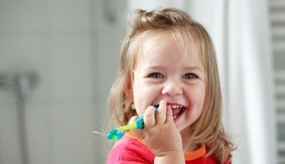 little girl brushing her teeth 