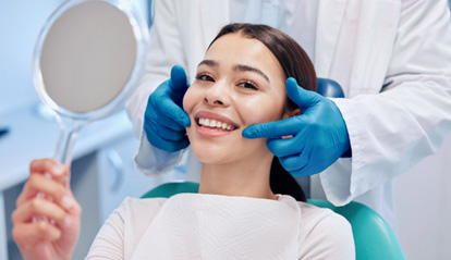 Patient smiling while holding small mirror
