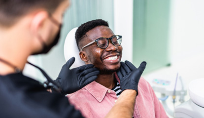 Dentist looking at patient's smile in treatment room