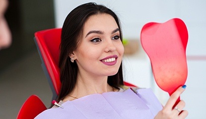 Woman looking at smile in mirror