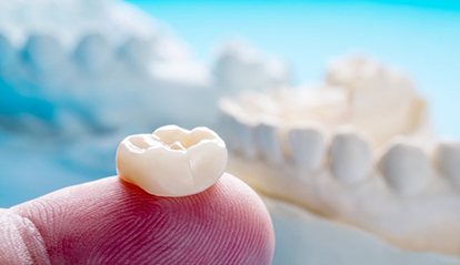 close up of a dental crown on a person’s finger 