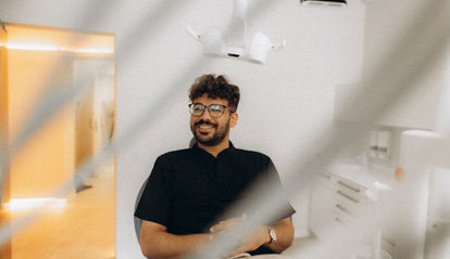 Patient with black glasses smiling in treatment chair