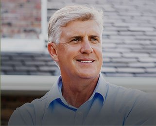 Older man in collared shirt smiling outdoors