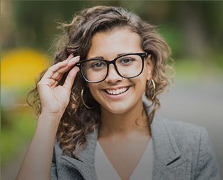 Smiling young woman adjusting her glasses