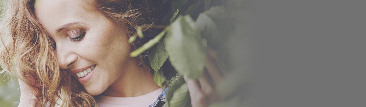 Side profile of smiling woman in the trees