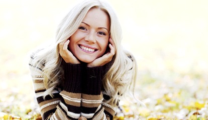 A young woman lying in the leaves and smiling