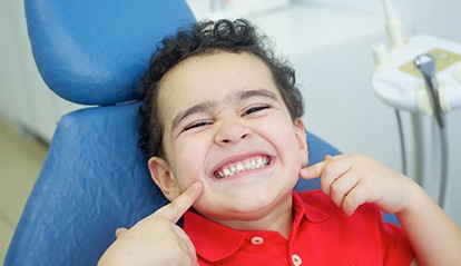 Little boy in dental chair showing teeth after receiving dental sealants in St. Albans