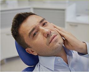 Man in pain holding jaw