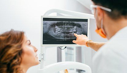 Dentist and patient looking at digial x-rays