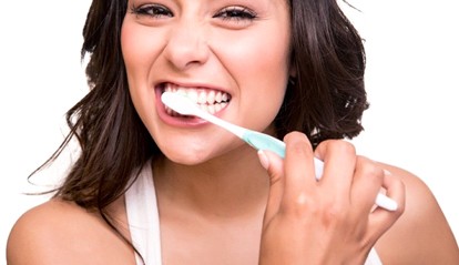 A woman brushing her teeth.