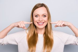 Woman pointing to her smile