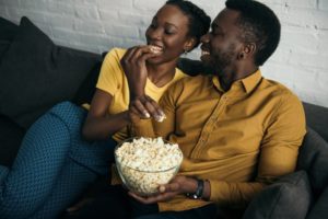 couple sitting on couch and eating popcorn 