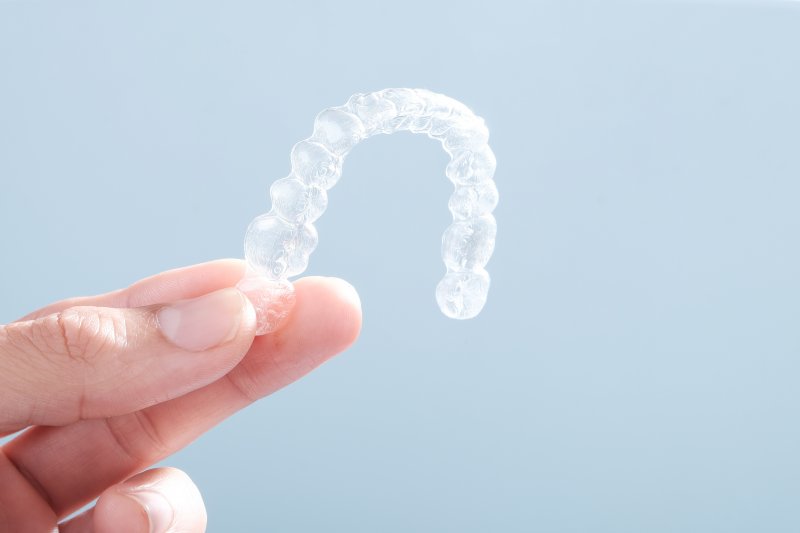 person holding Invisalign aligner