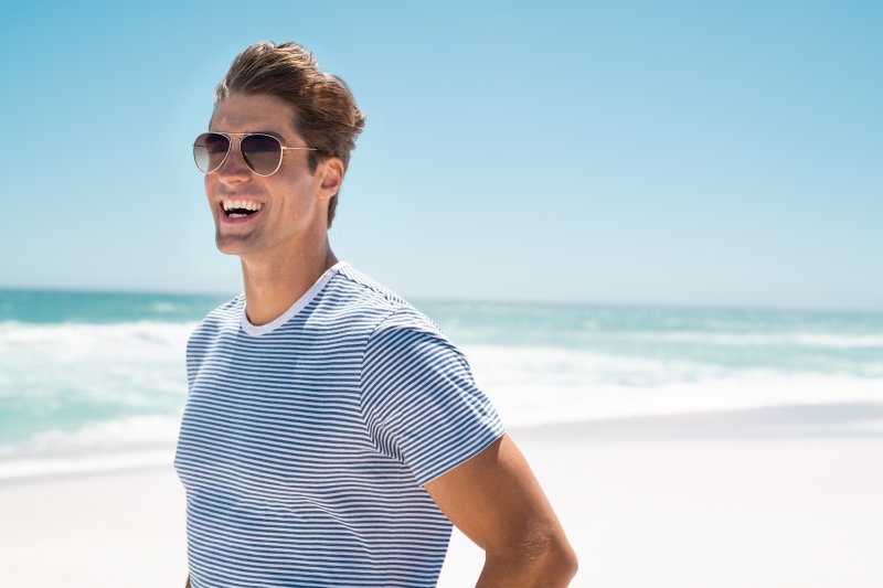 man smiling at beach during summer vacation