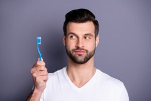 young man brushing his teeth