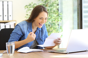 Woman smiling reading a letter about her tax refund