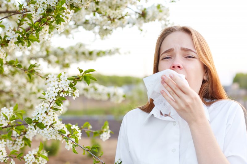 Woman with good dental health sneezing